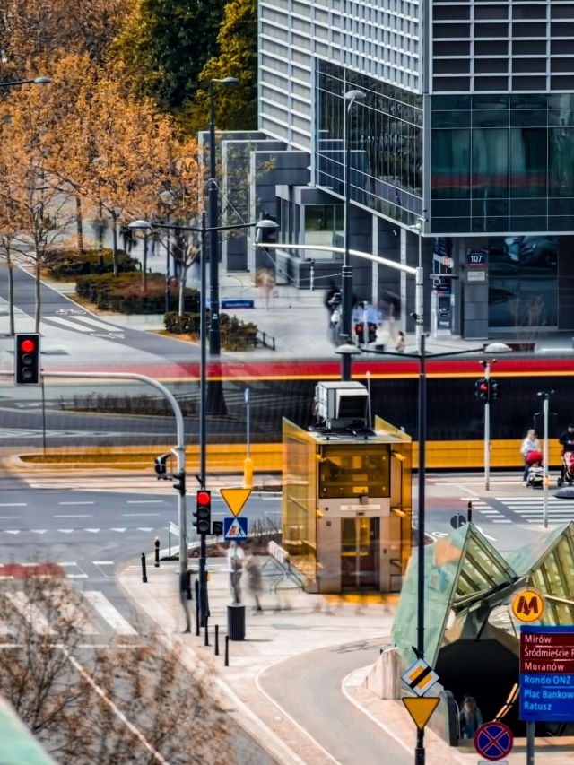 Jesienna ulica Warszawy, tramwaj, nowoczesne budynki, rozmyci przechodnie