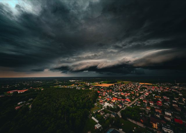 Ciemne chmury burzowe nad miastem i lasem, zdjęcie z drona